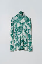 Green and white butterfly patterned long sleeve top on a white background