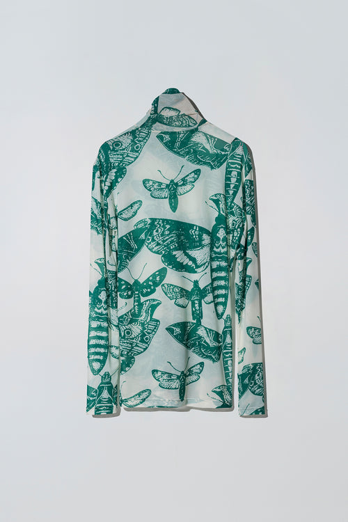 Green and white butterfly patterned long sleeve top on a white background