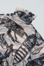 Black and nude butterfly patterned top on a white background