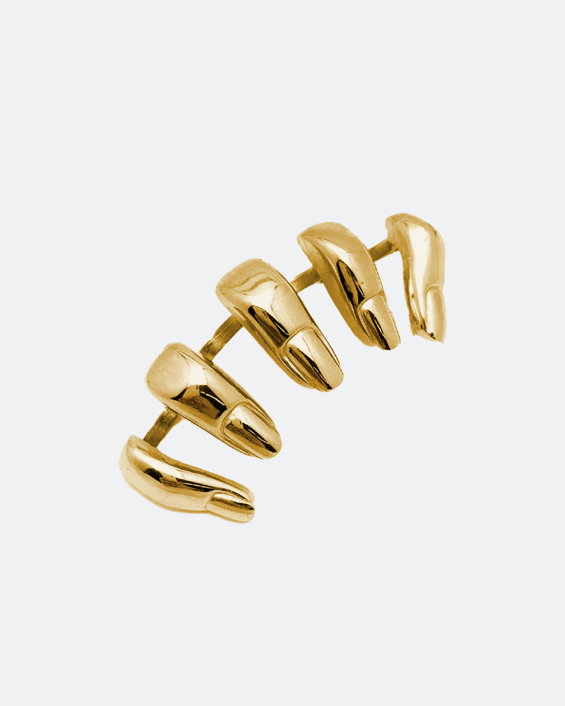 Gold knuckleduster over white background finger shapes Chris Habana