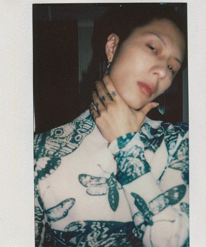 Model wearing a green and white butterfly patterned long sleeve top