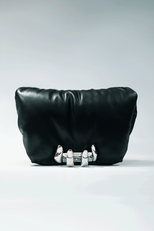Black leather handbag with a hand silver hardware grip on a white background