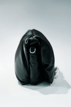 Black leather handbag with a hand silver hardware grip on a white background