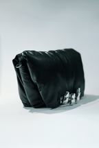 Black leather handbag with a hand silver hardware grip on a white background