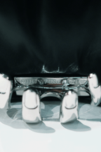 Close-up of a black handbag with a visible Dirty Pineapple brand name on a white background