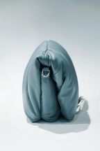 Blue leather handbag with a hand silver hardware grip on a white background