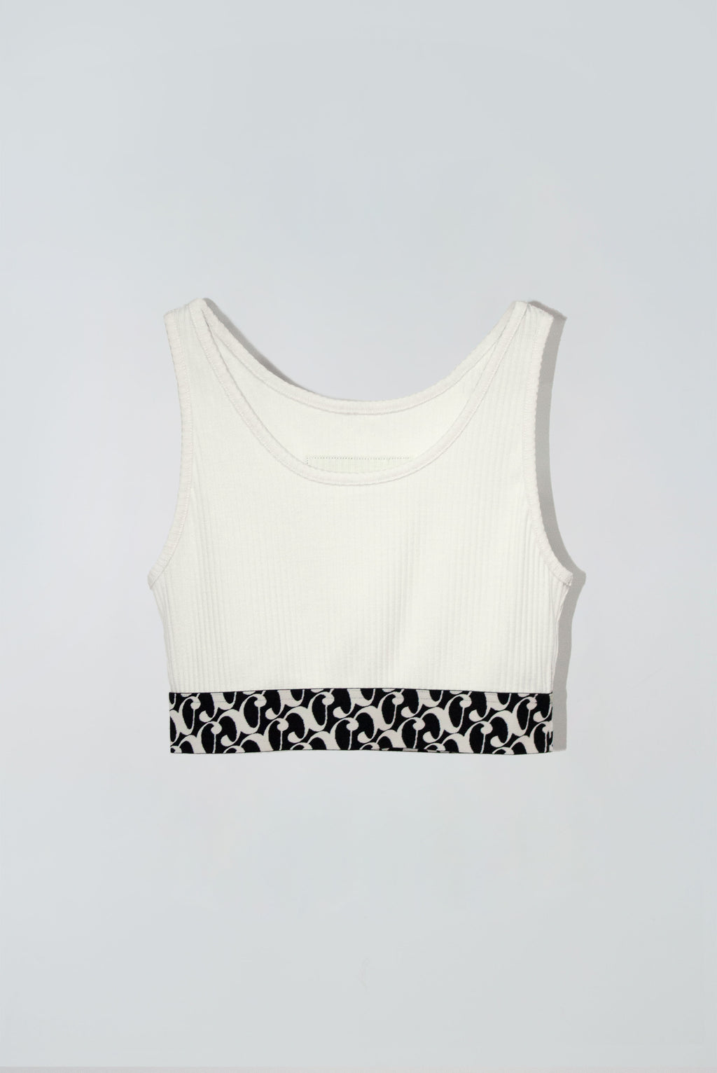 White crop tank top with a black and white patterned band at the bottom
