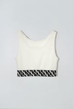 White crop tank top with a black and white patterned band at the bottom