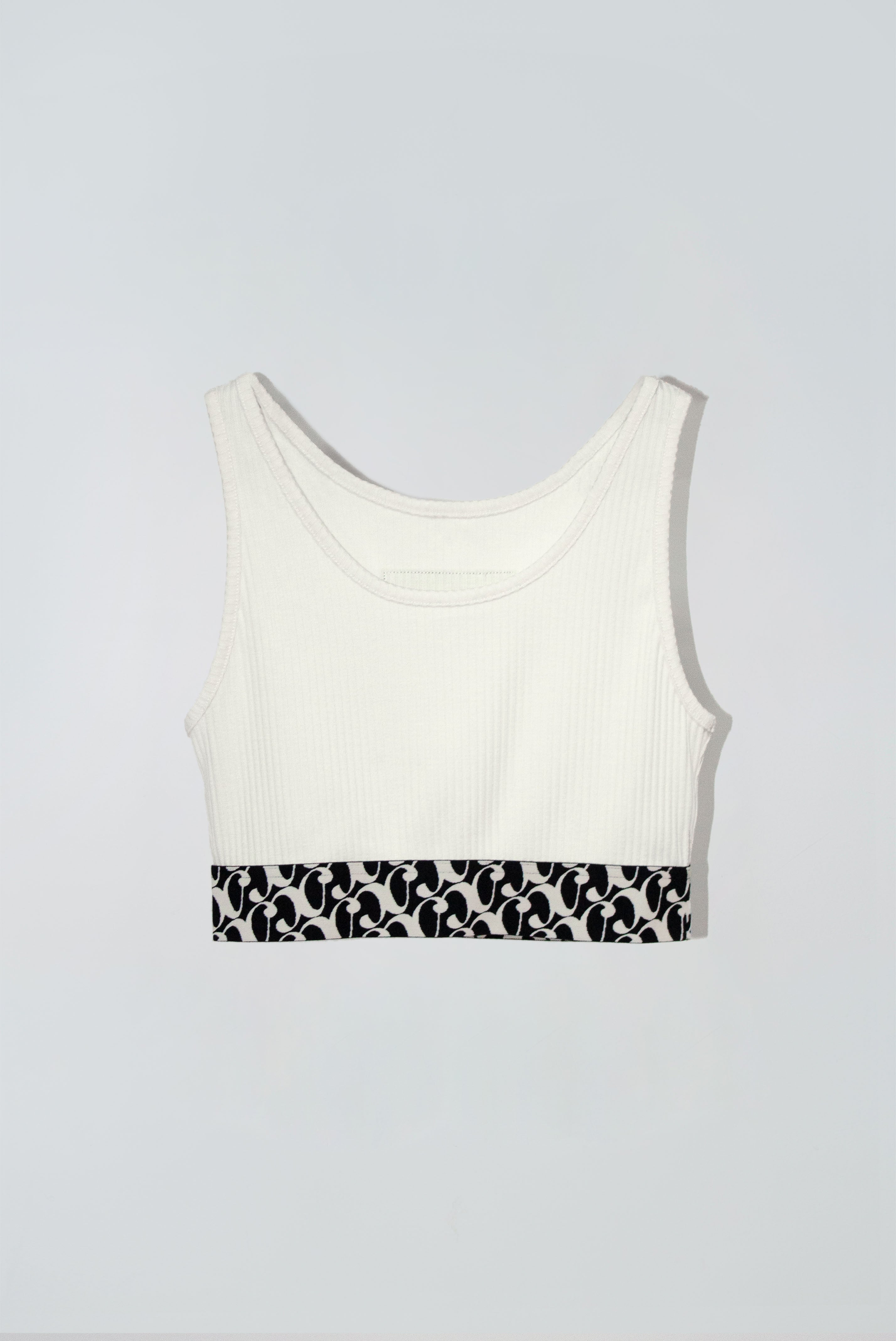 White crop tank top with a black and white patterned band at the bottom