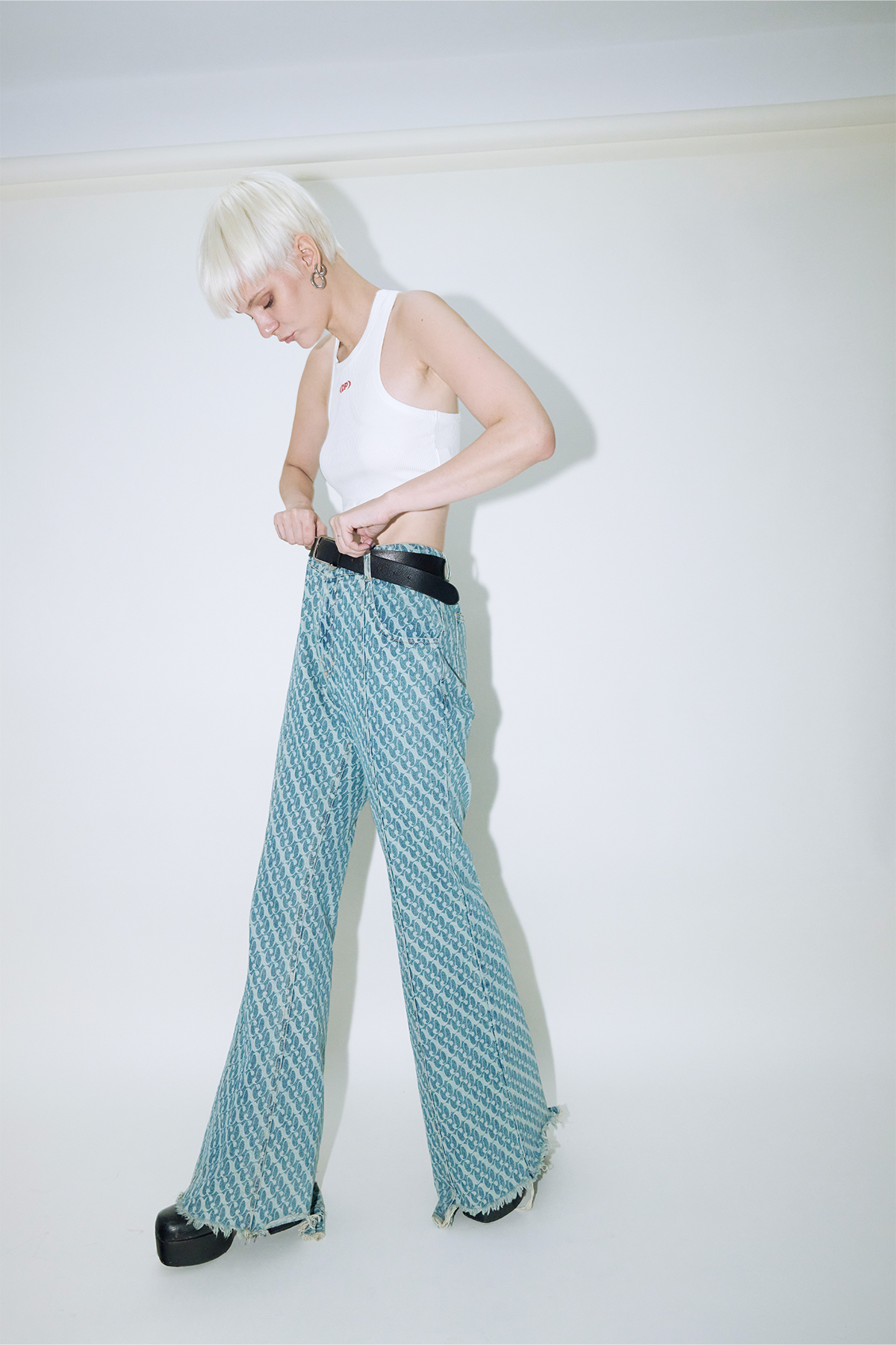 Model wearing Dirty Pineapple signature patterned denim pants flare fit over white background
