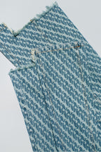 Close up of Dirty Pineapple signature patterned denim pants flare fit over white background