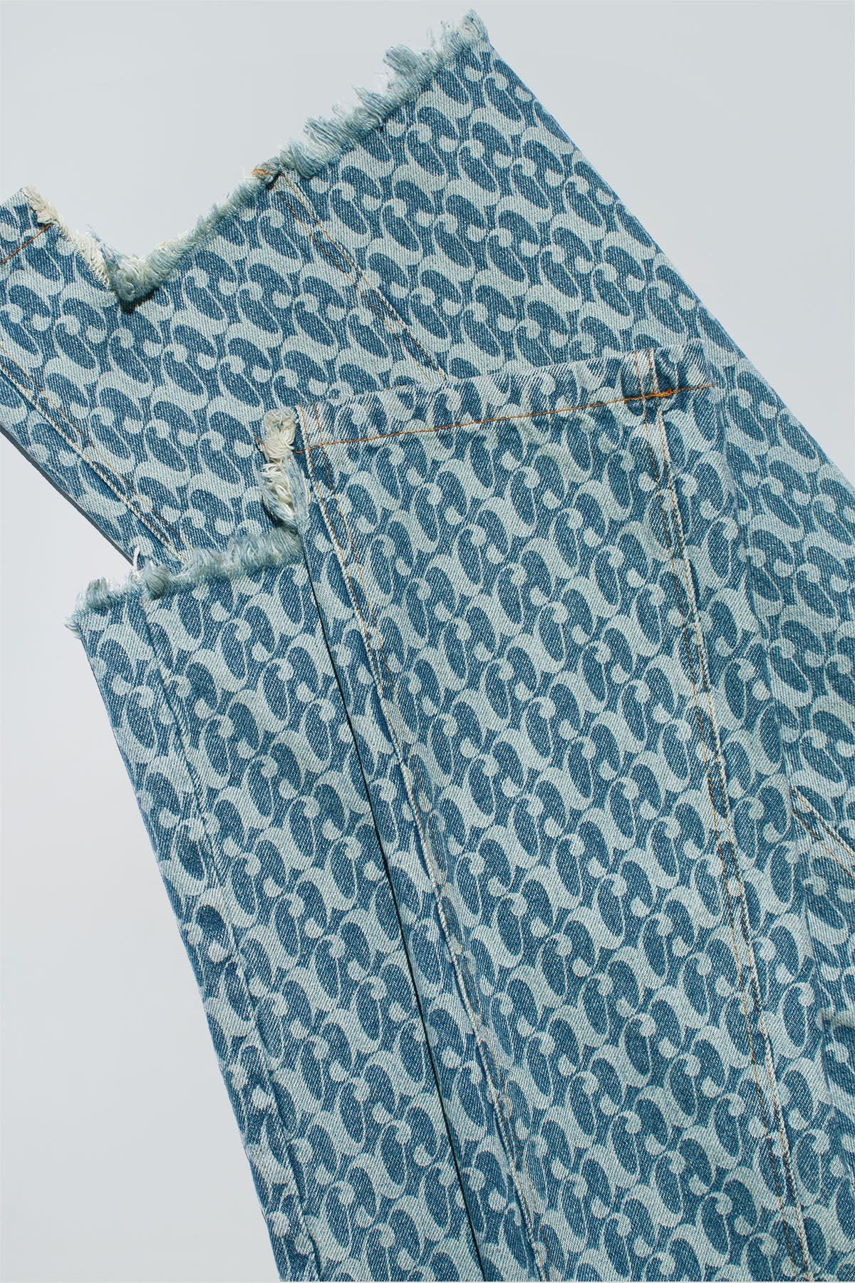 Close up of Dirty Pineapple signature patterned denim pants flare fit over white background