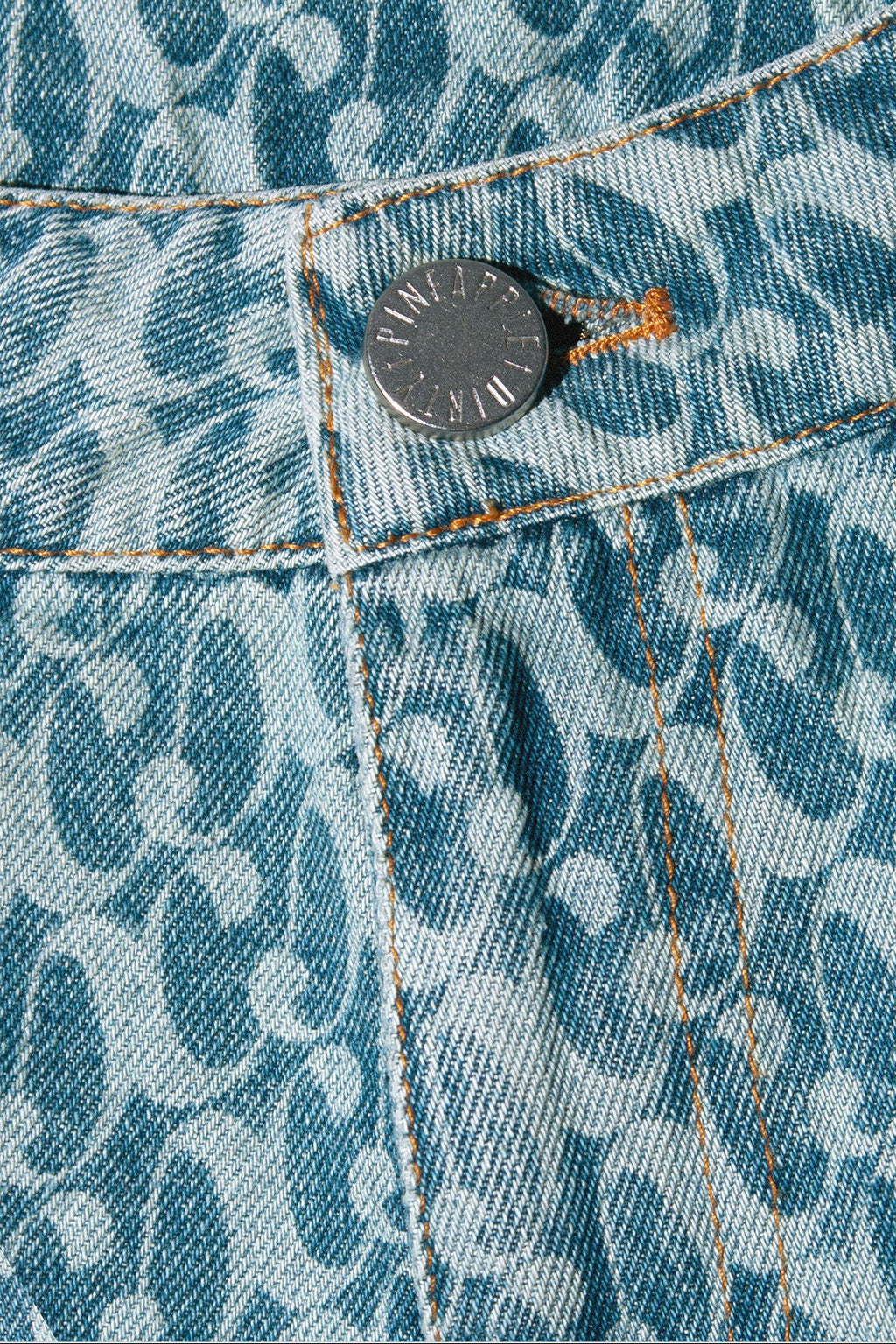 Close up of Dirty Pineapple signature patterned denim pants flare fit over white background