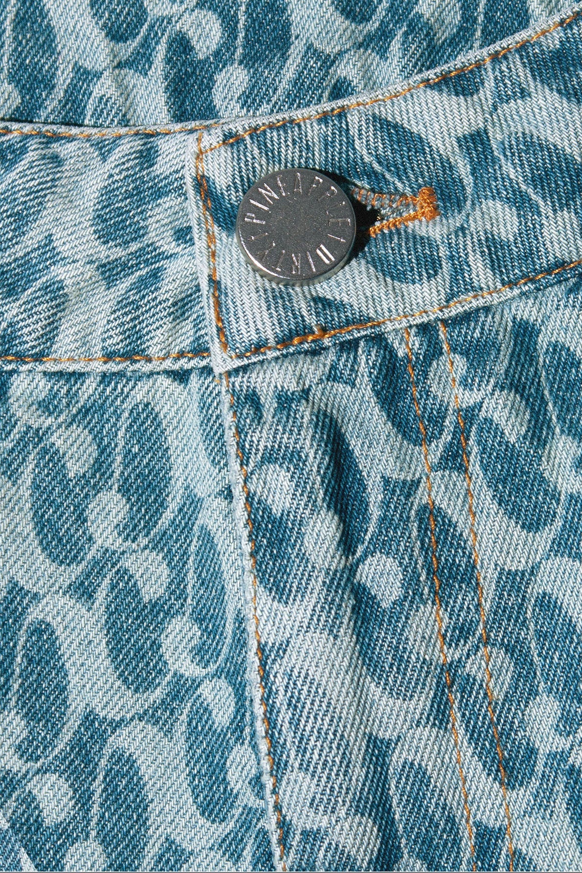 Close up of Dirty Pineapple signature patterned denim pants flare fit over white background