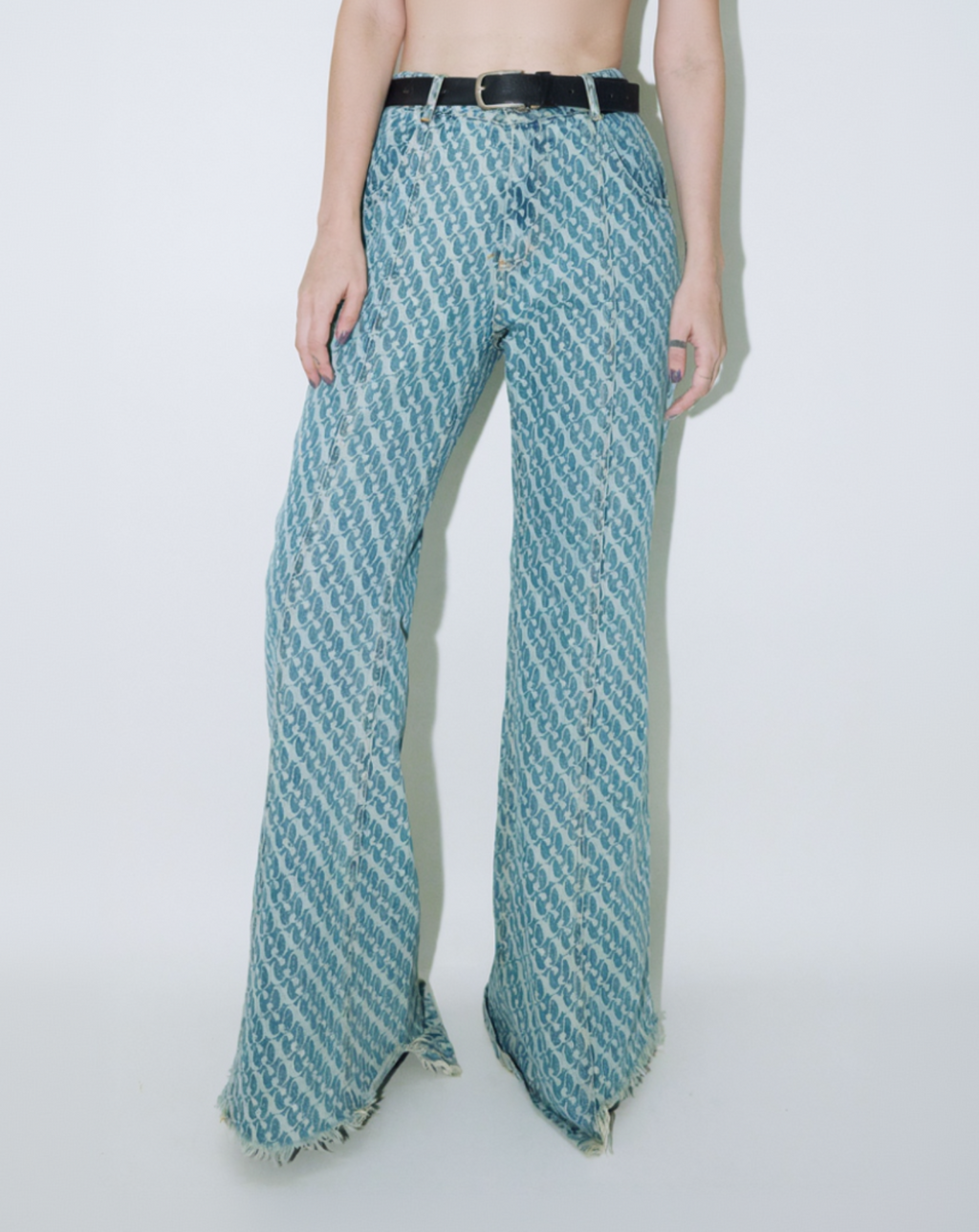 Model wearing Dirty Pineapple signature patterned denim pants flare fit over white background