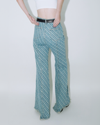 Close up of model wearing Dirty Pineapple signature patterned denim pants flare fit over white background