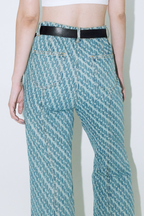 Close up of model wearing Dirty Pineapple signature patterned denim pants flare fit over white background