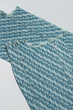 Close up of Dirty Pineapple signature patterned denim pants straight fit over white background