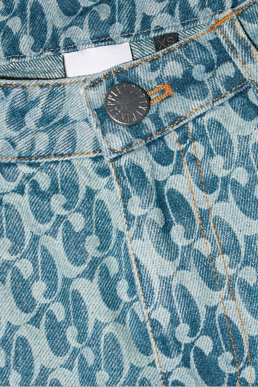 Close up of Dirty Pineapple signature patterned denim pants straight fit over white background