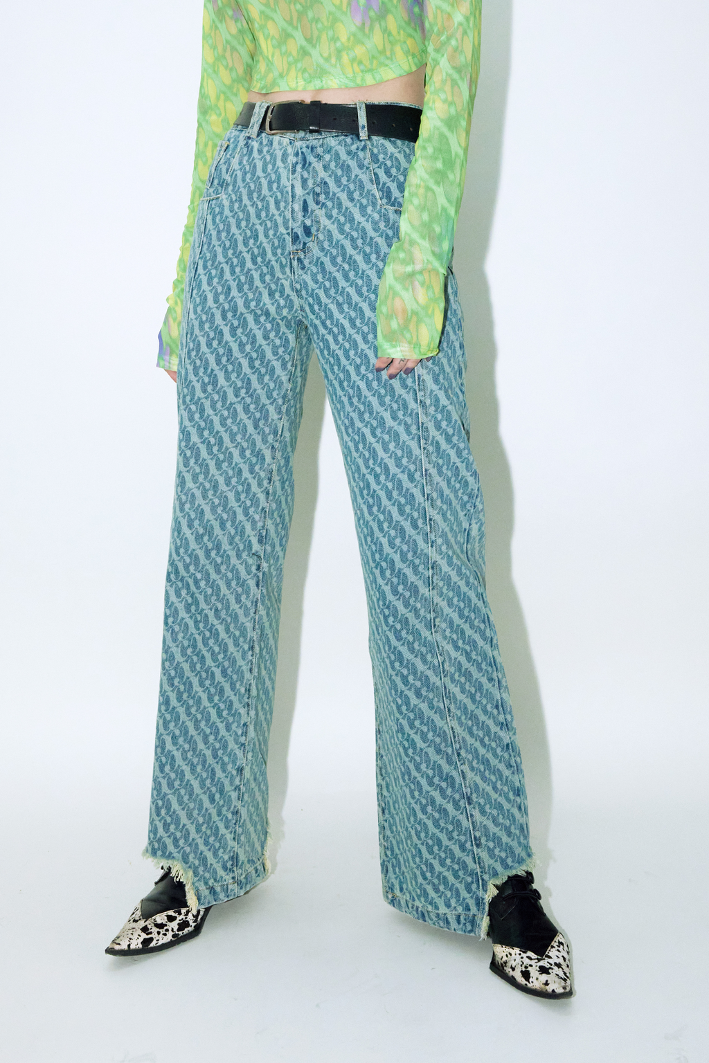 Close up of model wearing Dirty Pineapple signature patterned denim pants straight fit over white background