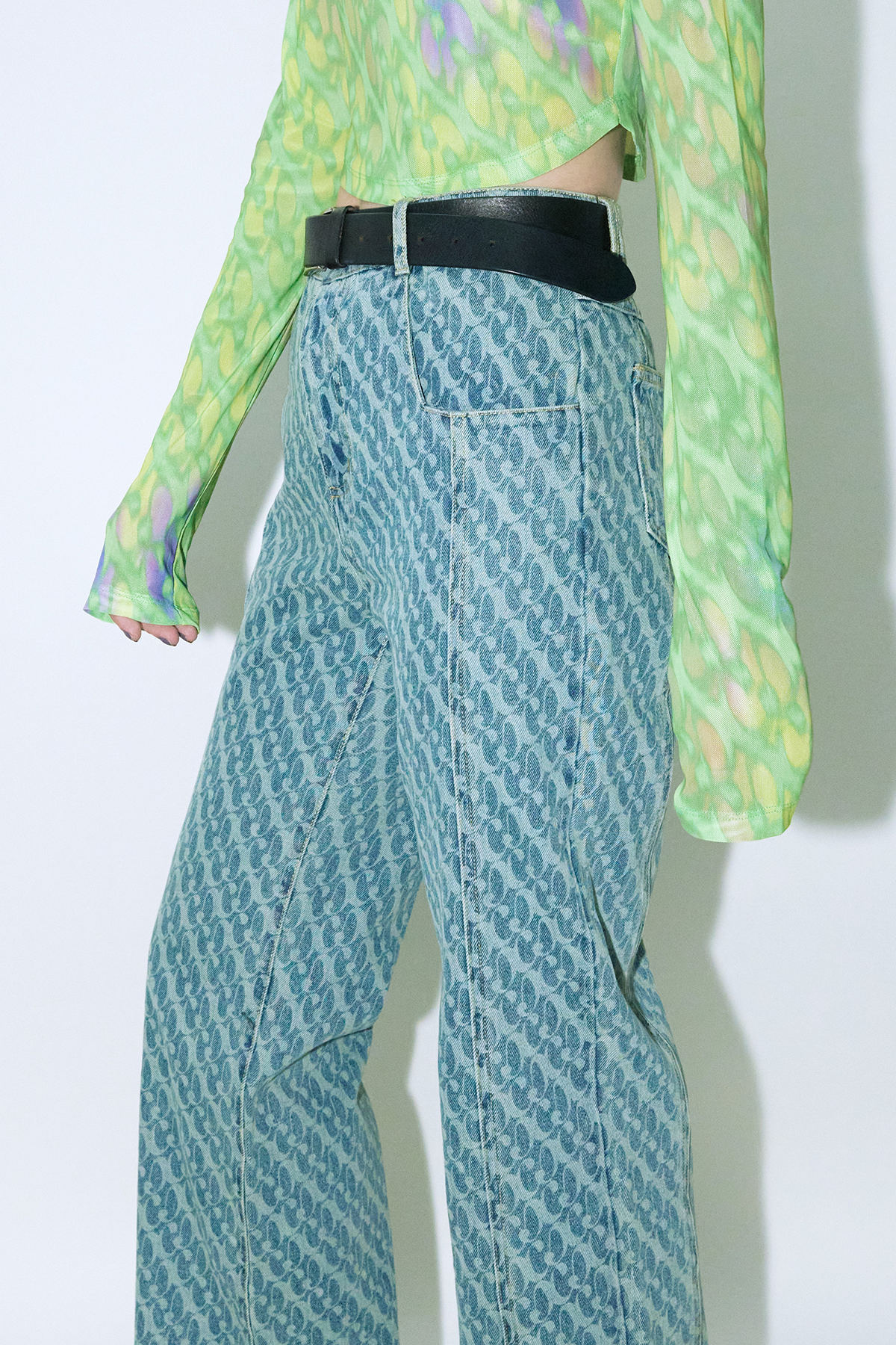 Close up of model wearing Dirty Pineapple signature patterned denim pants straight fit over white background