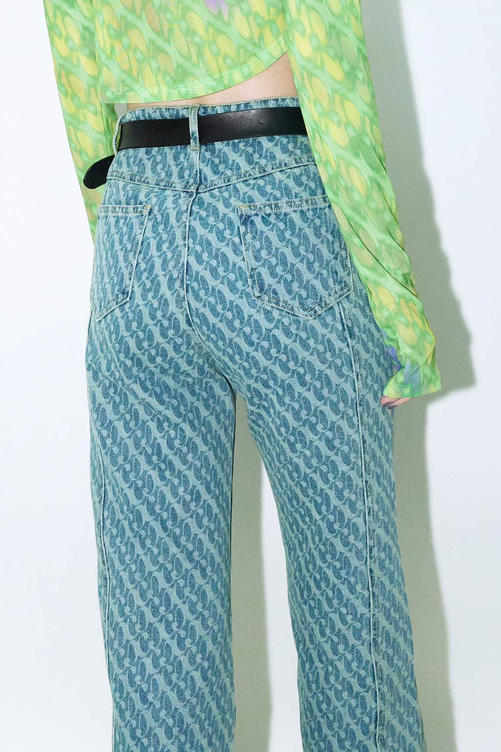 Close up of model wearing Dirty Pineapple signature patterned denim pants straight fit over white background